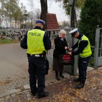 policjanci zakładają kobiecie odblaski