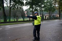policjant na drodze tarczą daje sygnał do zatrzymania