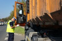 policjant z drogówki kontroluje dokumentację przy ciężarówce