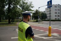 policjant stoi przy znaku przejście dla pieszych