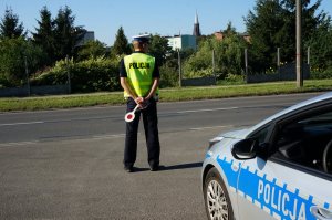policjant ruchu drogowego stoi obok radiowozu